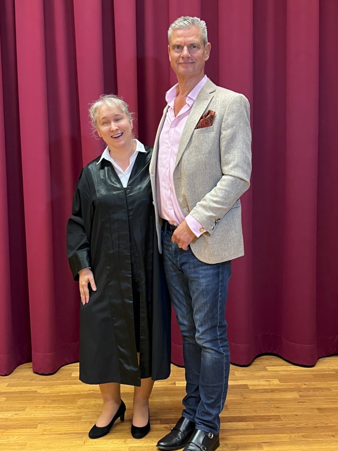 Pamela Pabst links, Ingo Hoppe rechts, beide stehend auf Stabparkett vor weinrotem Vorhangsaum